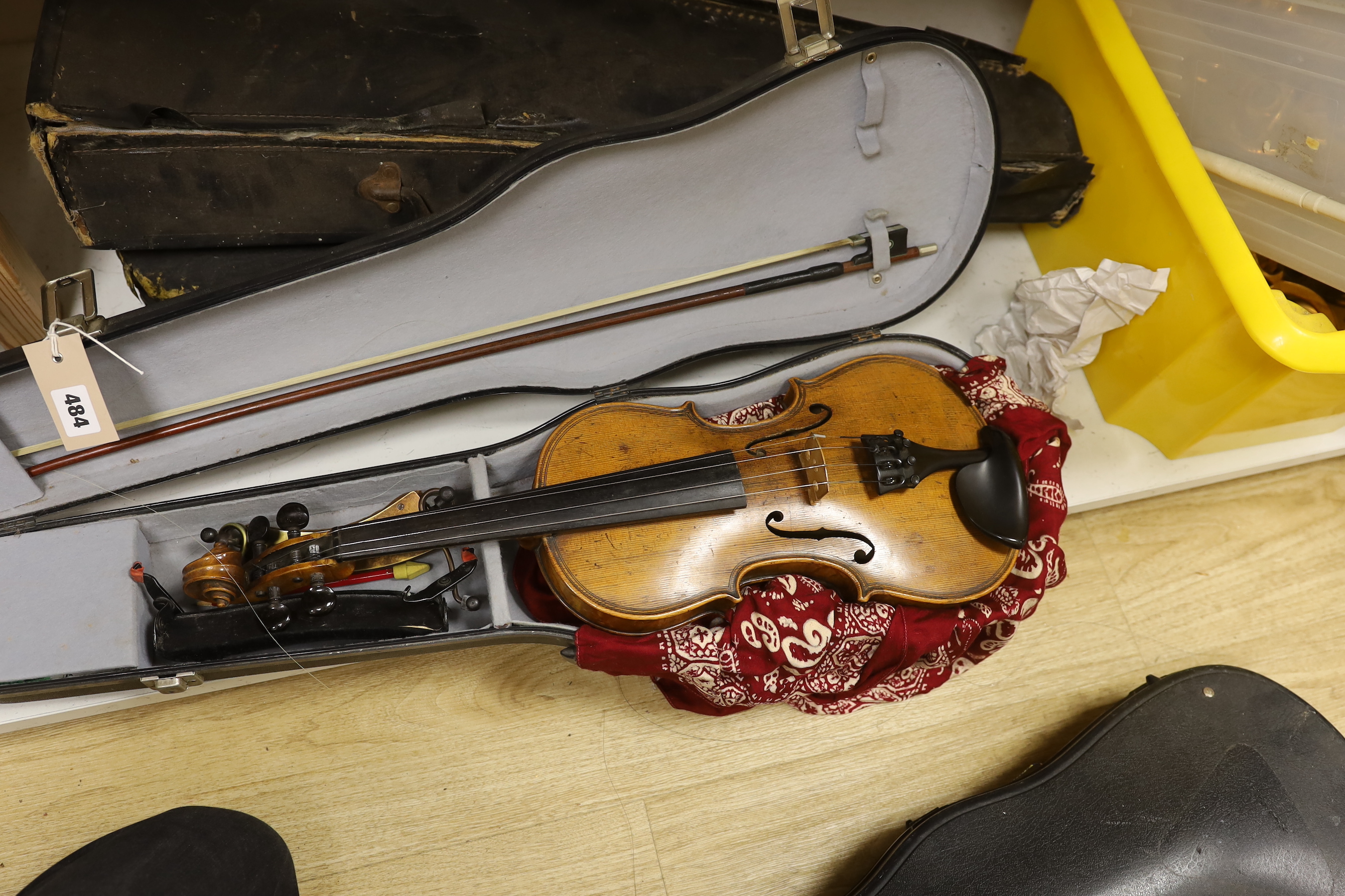 A violin, labelled Giovan Paulo Maggini, and three other violins, with bows in cases